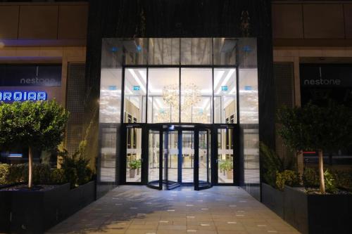 an entrance to a building with a revolving door at Nest One Luxe, Элитные апартаменты с балконом и видом на фонтан Tashkent City Park 110 in Tashkent