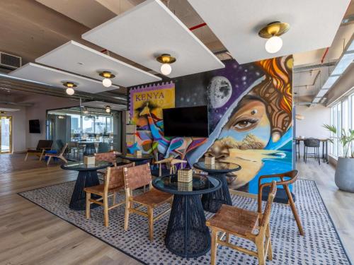 um mural num restaurante com mesas e cadeiras em Mercure Nairobi Upper Hill em Nairobi