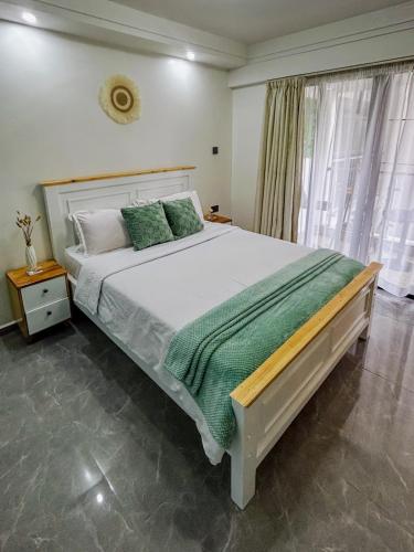 a bedroom with a large bed and a window at Urban Shell Retreat- Kileleshwa in Nairobi