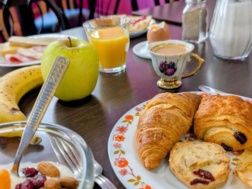 a table with a plate of breakfast foods and an apple at greet Grenoble Centre Gare Accor Hotel in Grenoble