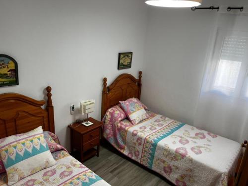 a bedroom with two beds and a table with a lamp at La casita de la punta in Isla del Moral