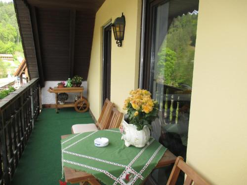 a table with a vase of flowers on a balcony at Apartments in Behringersmühle in Gößweinstein