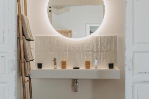 a bathroom with a white sink and a mirror at Sainte Raphine in Fargues-Saint-Hilaire