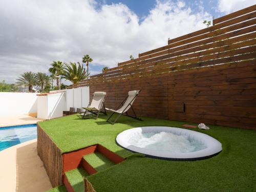 a backyard with a hot tub in the grass at Florida Home Private pool and Jacuzzi in San Bartolomé