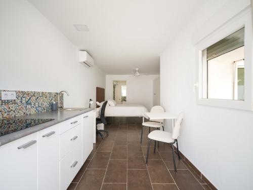 Una cocina con gabinetes blancos y una mesa y sillas. en Florida Home Private pool and Jacuzzi, en Playa del Inglés