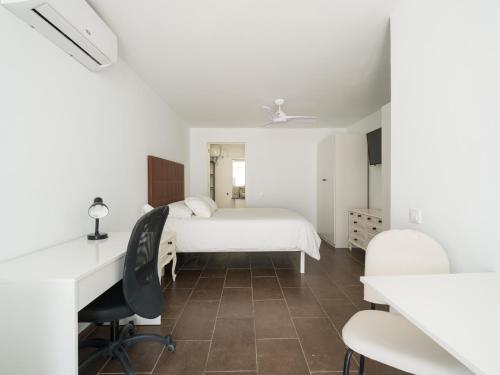 Un dormitorio blanco con una cama y un escritorio. en Florida Home Private pool and Jacuzzi, en Playa del Inglés