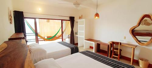 a bedroom with two beds and a window at Posada Ziga Playa in Mazunte