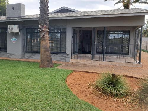 a house with a palm tree in front of it at Greenfield in Klerksdorp