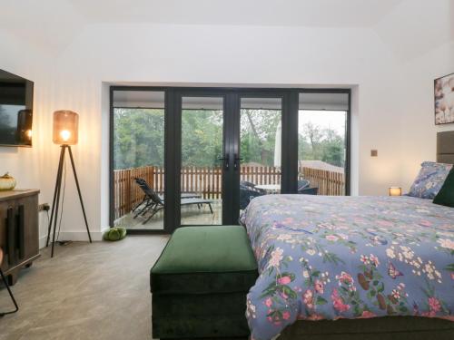 1 dormitorio con cama y vistas a la terraza en The Hay Barn, en Gloucester