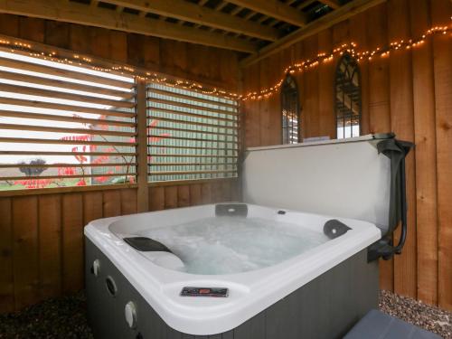 bañera grande en una habitación con luces en The Hay Barn, en Gloucester