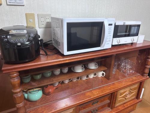 a microwave and a toaster oven on a wooden shelf at KominkaGlamping NAYA - Vacation STAY 20482 in Chosei