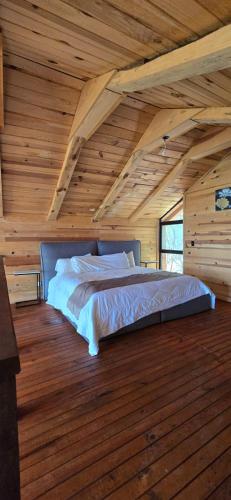 a bed in a room with a wooden ceiling at La Cabaña 16 Mazamitla in Mazamitla