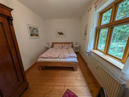 a bedroom with a bed and two windows at Hus in Huddel - Worpswede - Teufelsmoor in Osterholz-Scharmbeck