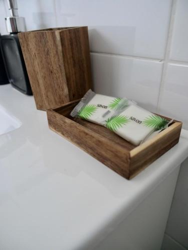 a wooden box with two pillows on a counter at La Galante, studio proche plage privée in Grand-Bourg