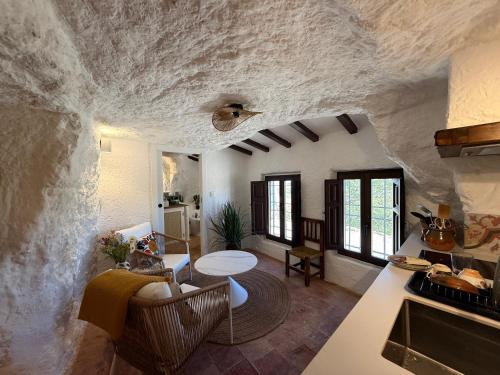 ein Wohnzimmer mit Tisch und Küche in der Unterkunft Magical Cave in Spain - Boutique Luxury Stay in Nature in Chinchilla de Monte-Aragón