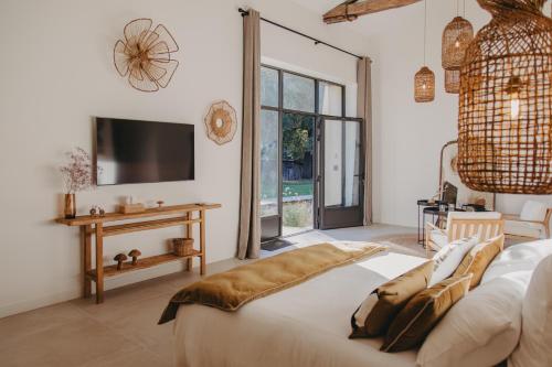 a bedroom with a bed and a tv on a wall at Sainte Raphine in Fargues-Saint-Hilaire