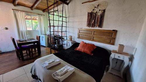 a bedroom with a bed and a table in it at Las Acacias Refugio in La Falda