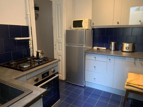 a kitchen with a stove and a refrigerator at Vintage Room in private house in Bucharest