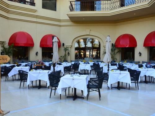 um restaurante com mesas brancas, cadeiras e guarda-sóis em Rixos Sharm El Sheikh - Adults Only 18 Plus em Sharm El Sheikk