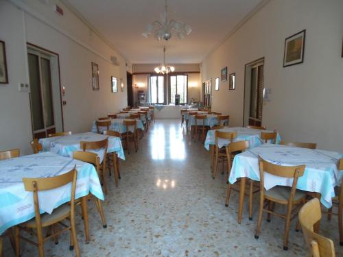 una habitación llena de mesas y sillas con mantel blanco en Casa Caburlotto, en Venecia