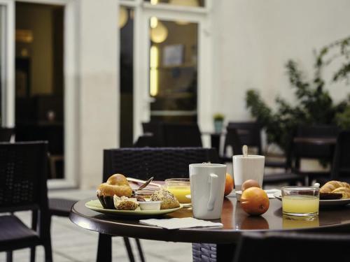 Una mesa con platos de comida y bebidas sobre ella. en ibis Styles Marseille Gare Saint-Charles, en Marsella