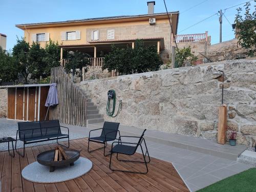 a patio with chairs and a fire pit in front of a building at Quinta Cunha in São Pedro do Sul