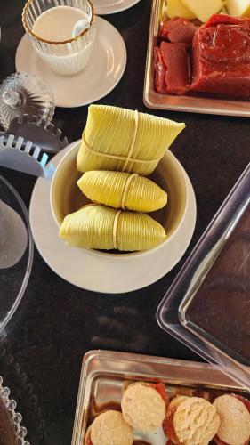 a table topped with plates of food with corn appetizers at Pousada Recanto e Aconchego Capitolio in Capitólio