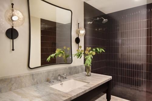 un baño con lavabo y espejo en Kimpton Mirador Pacific Grove Monterey by IHG, en Pacific Grove