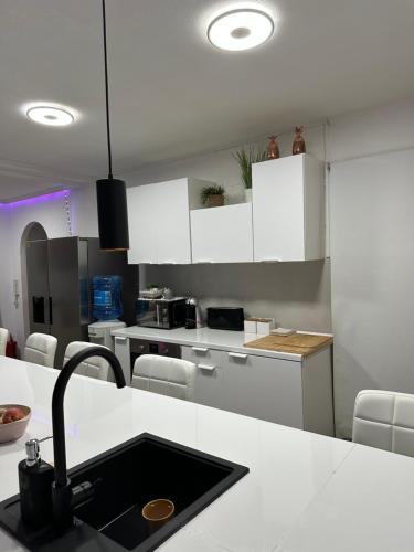 La cuisine est équipée de placards blancs et d'un évier noir. dans l'établissement Stag hendo25pax Only 10min to the PARTY area DESPEDIDAS 25pax 10 min de la zona de fiesta Consultar precio, à Benidorm