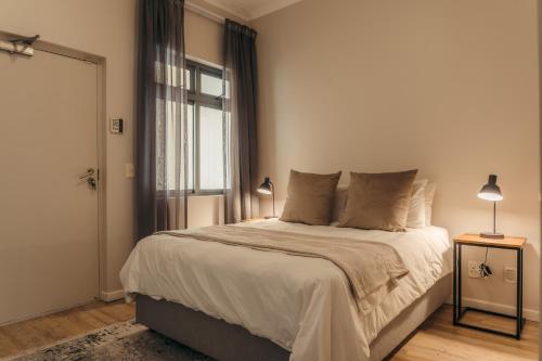 une chambre avec un grand lit avec une fenêtre dans l'établissement Sunwave at Empire, au Cap