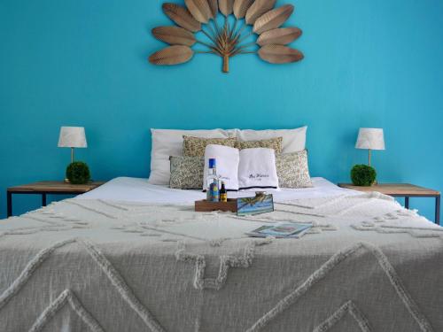 a blue bedroom with a large bed with a blue wall at La Galante, studio proche plage privée in Grand-Bourg