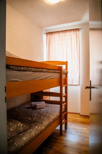 two bunk beds in a small room with a window at Apartman Gnječ Kupres in Kupres