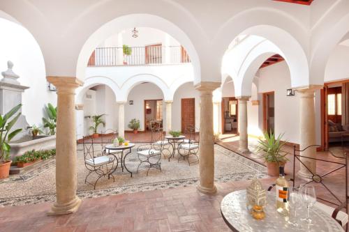 a courtyard with tables and chairs in a building at Apartamentos Casa del Aceite in Córdoba