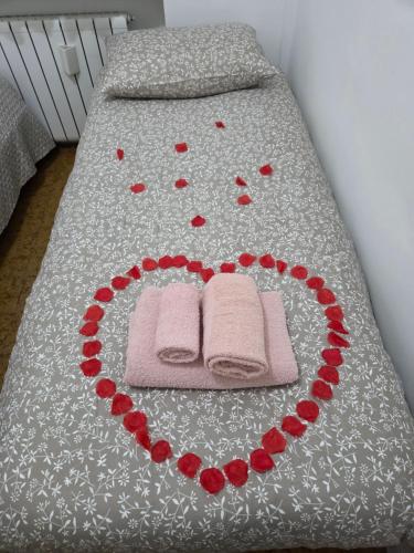Una cama con un corazón hecho de rosas rojas en Casa Nanà Beach, en Lido Adriano