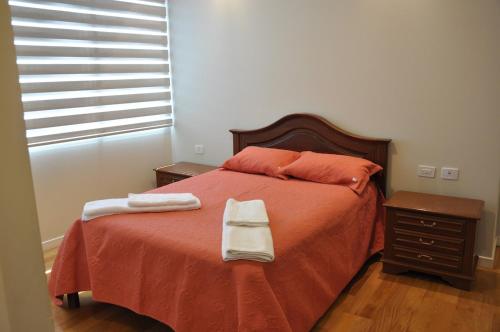 a bedroom with a bed with two towels on it at Condo en Cochabamba in Cochabamba