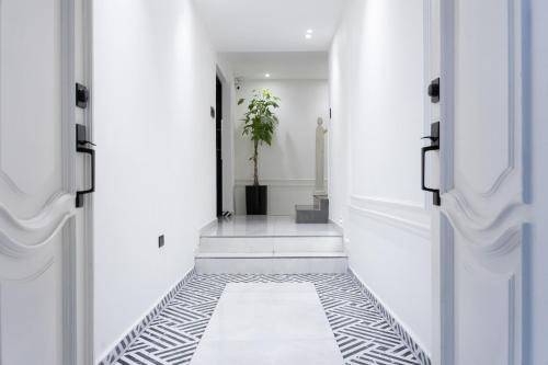 a hallway with white walls and black and white flooring at Hotel Boutique Las Mesetas in San Pedro Sula