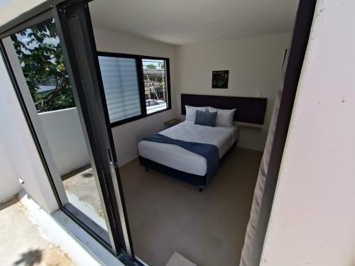 - une chambre avec un lit et quelques fenêtres dans l'établissement Deptos Modernos Colonia México, à Mérida