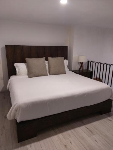 a bedroom with a large bed with white sheets and pillows at Casa Monarcas - Josefina (with AC) in Guadalajara