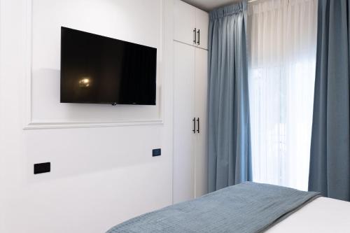 a bedroom with a bed with a television on the wall at Hotel Boutique Las Mesetas in San Pedro Sula