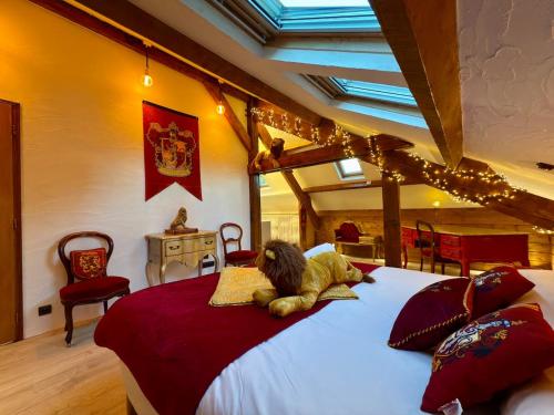 - un ours en peluche posé sur un lit dans une chambre dans l'établissement La maison des apprentis sorciers Séjour enchanteur, 