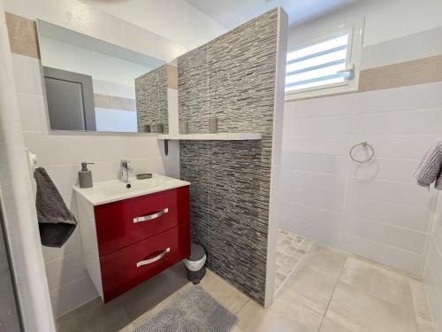Un baño con un lavabo rojo y una ducha. en Chez Patricia - vue panoramique au Carbet, en Le Carbet