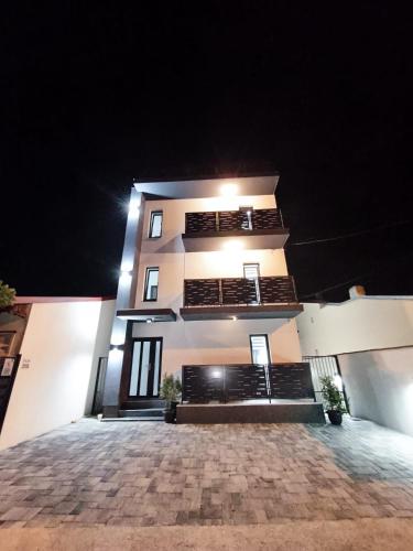 a tall white building with lights on it at night at ROA Residence - premium apartments in Ploieşti