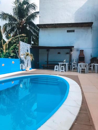 a large blue swimming pool next to a patio at Refúgio Lumare in Maragogi