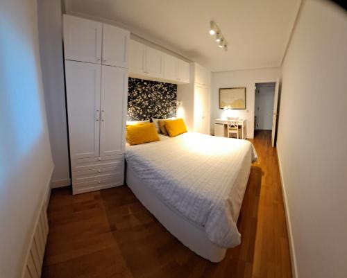 a bedroom with a large white bed with yellow pillows at Luminoso y Azul VUT 4654 AS in Avilés