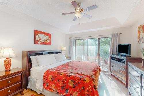 a bedroom with a bed with a ceiling fan and a television at Camp Warnecke Estates Unit B109 in New Braunfels