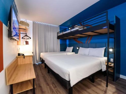 a bedroom with two beds and a bunk bed at ibis Styles Poços de Caldas in Poços de Caldas