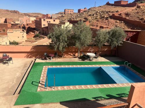 a swimming pool in the middle of a building with a mountain at Kasbah La Famille Berbère in Boumalne