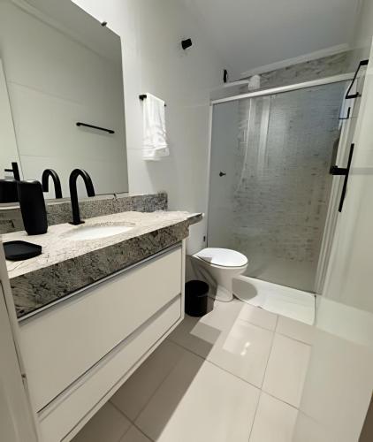 a bathroom with a toilet and a sink and a shower at Central accommodations! Close to everything you need! in Barreiras