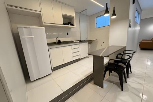 a kitchen with a table and chairs and a refrigerator at Apartamento no centro! Próximo a tudo! in Barreiras