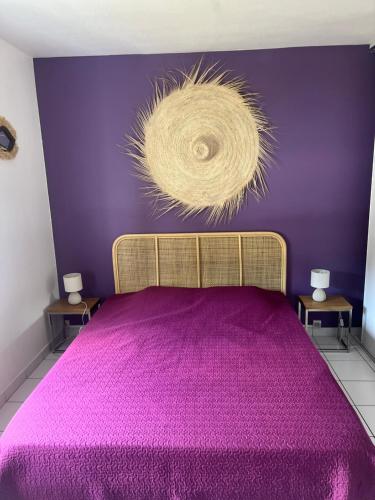 a purple bedroom with a bed with a purple wall at T2 tout confort Vue Panoramique in Sainte-Anne